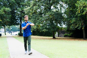 man using smart watch, wearing ear bud headphones
