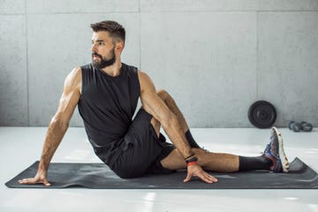 man in 40s stretching in gym