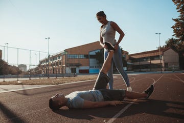 female fitness instructor helping young man with an exercise