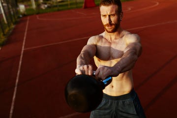 hombre entrenando con kettlebell en el parque