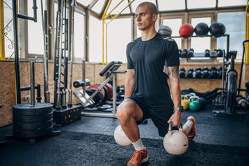 one man, young man exercises with kettlebells in gym.