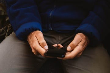 hands holding a smartphone while seated