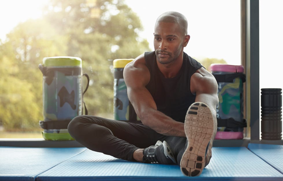 a man stretching his hamstrings in the gym