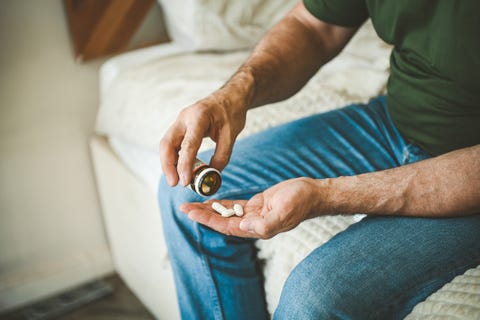 mature adult man in cozy interior of bedroom ( taking medication)