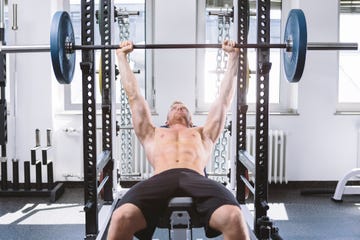 physical athlete doing bench presses