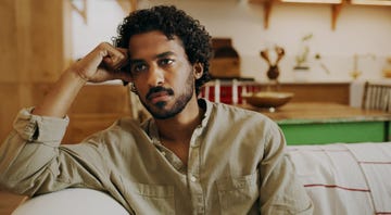 shot of a handsome young man sitting alone on the sofa at home and feeling stressed