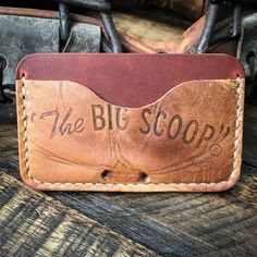 a brown leather wallet with the words, the big scoop on it