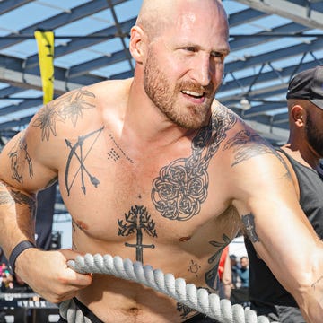 Two individuals engaged in a rope pulling exercise during a fitness event. Two individuals engaged in a rope pulling exercise during a fitness event.