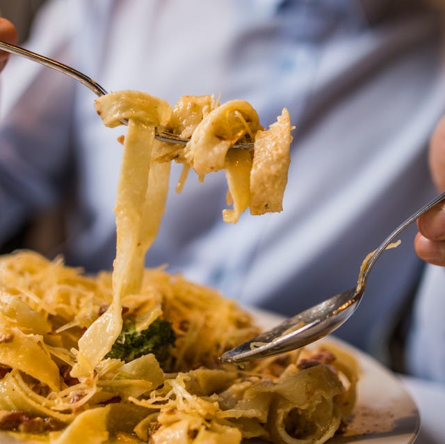 hombre comiendo pasta close up of unrecognizable man eating pasta for lunch.
