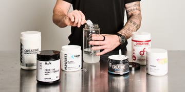 A person preparing a creatine supplement in a jar. A person preparing a creatine supplement in a jar.
