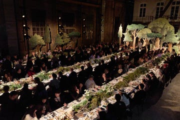large banquet with guests seated at multiple tables adorned with greenery and floral arrangements large banquet with guests seated at multiple tables adorned with greenery and floral arrangements