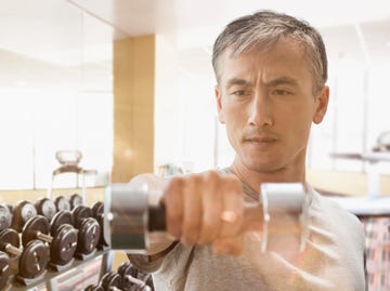 Chinese man lifting weights in gym chinese man lifting weights in gym