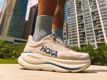 Close-up of a sneaker outdoors with a city skyline in the background. Close-up of a sneaker outdoors with a city skyline in the background.