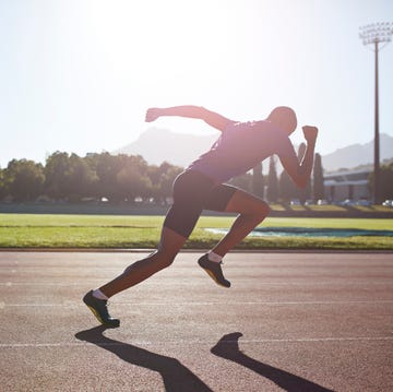 Male athlete sprinting out of start block male athlete sprinting out of start block