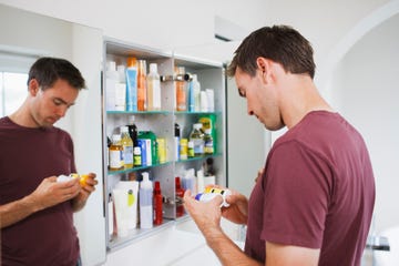 Man looking at bottles from medicine cabinet man looking at bottles from medicine cabinet
