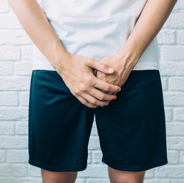 man wearing shorts holding genitals. Men's health, venereologist, sexual disease man wearing shorts holding genitals men's health, venereologist, sexual disease