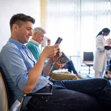 Patients sitting in waiting room using mobile phone patients sitting in waiting room using mobile phone