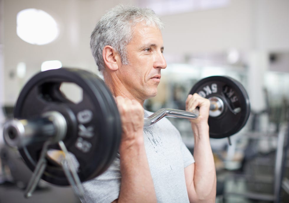 Portrait of smiling man holding barbell in gymnasium portrait of smiling man holding barbell in gymnasium