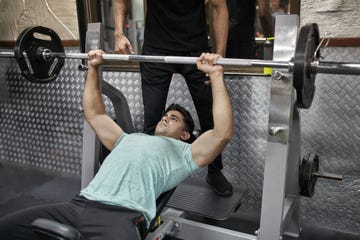 Young man practicing bench press at health club young man practicing bench press at health club